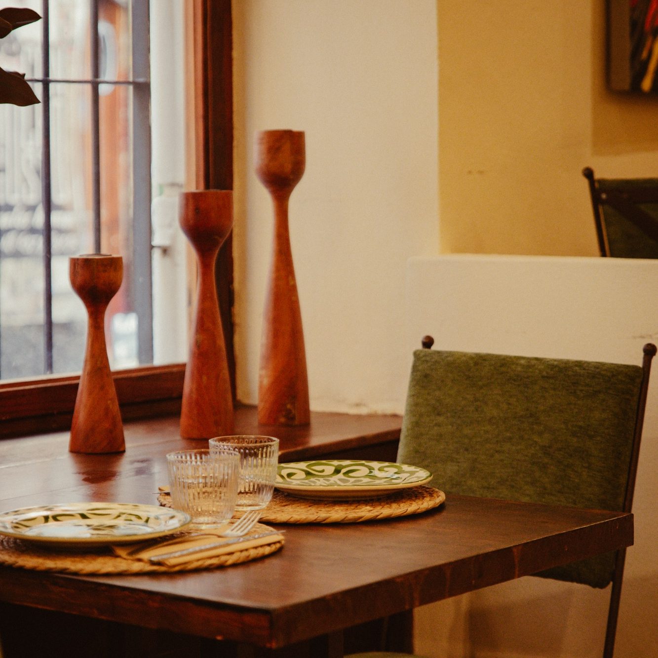 Mesa de Casa Milpa preparada con vajilla y jarrones de arcilla de inspiración mexicana.